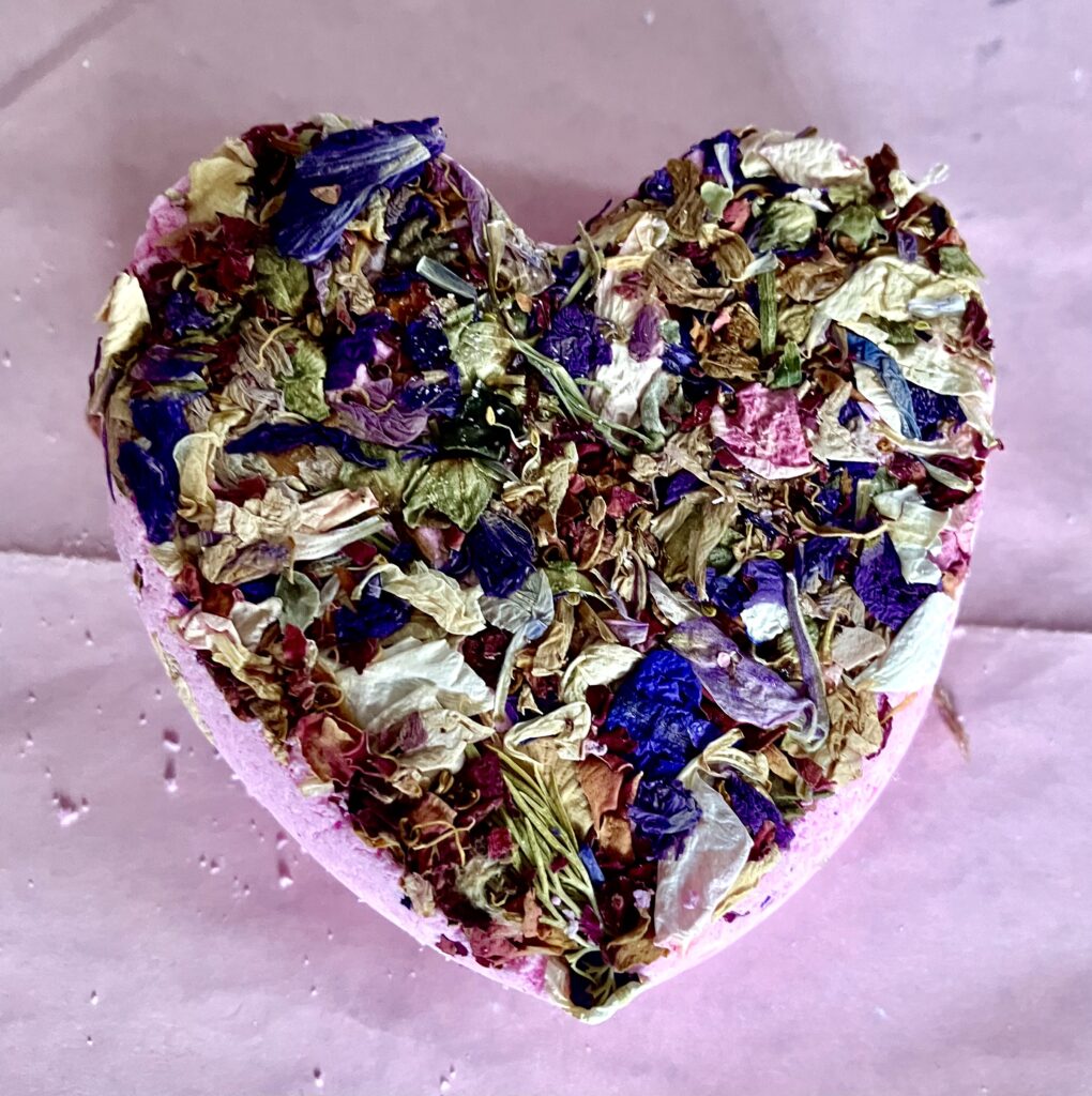 Blue heart shaped bath-bomb with a mix of dried flowers